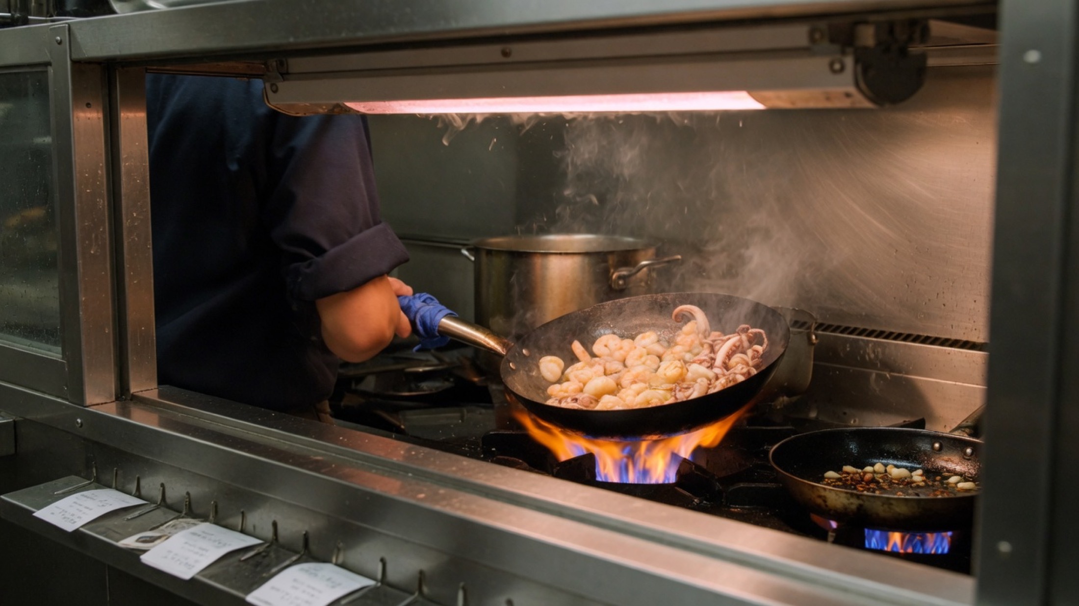 Seafood in flame against black glass, placeholder. Not a floor plan and not a named dish.